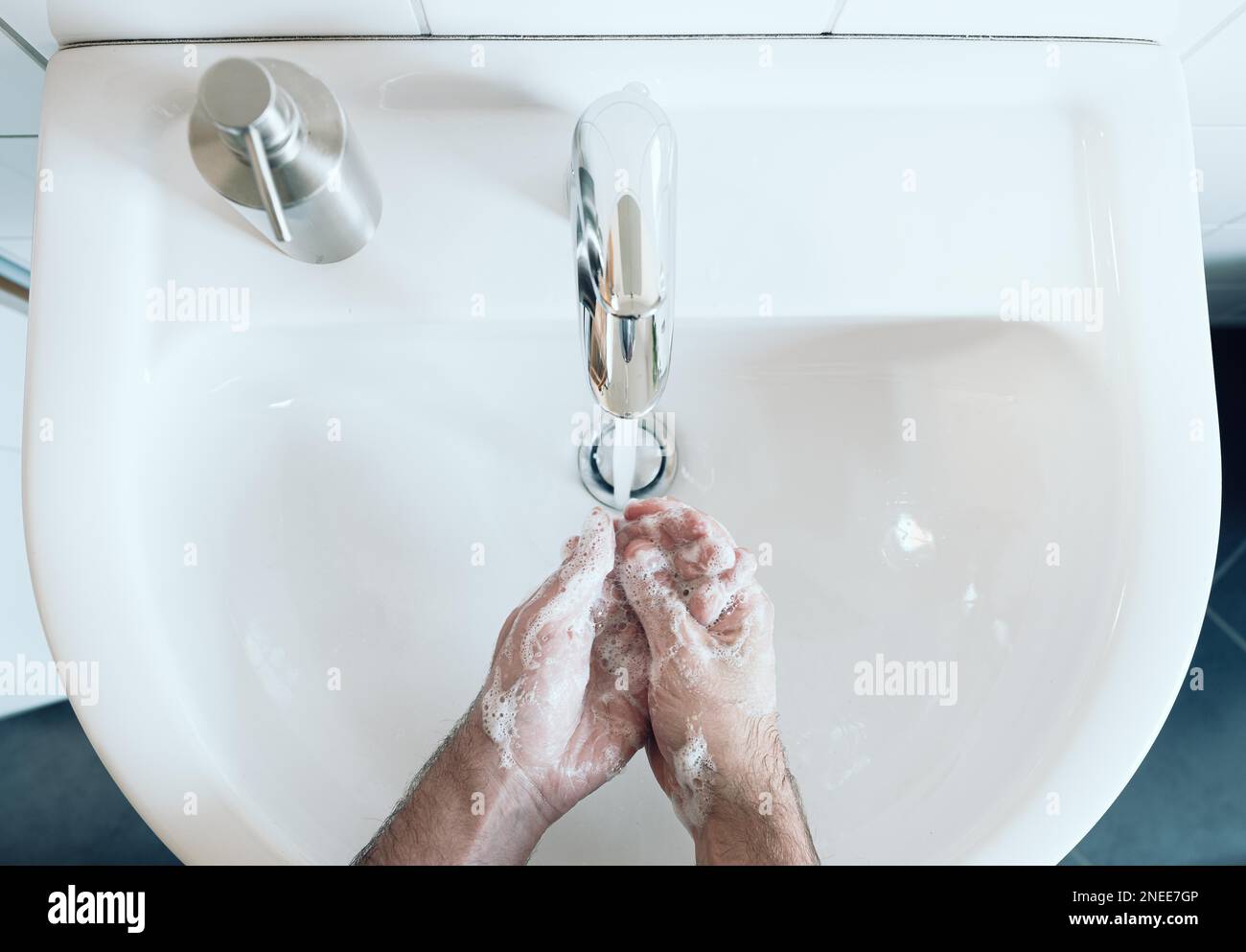 vue de dessus de la personne se laver soigneusement les mains à l'évier de salle de bains avec du savon et de l'eau chaude, mesure d'hygiène pendant la pandémie de covid-19 de coronavirus pour éviter Banque D'Images