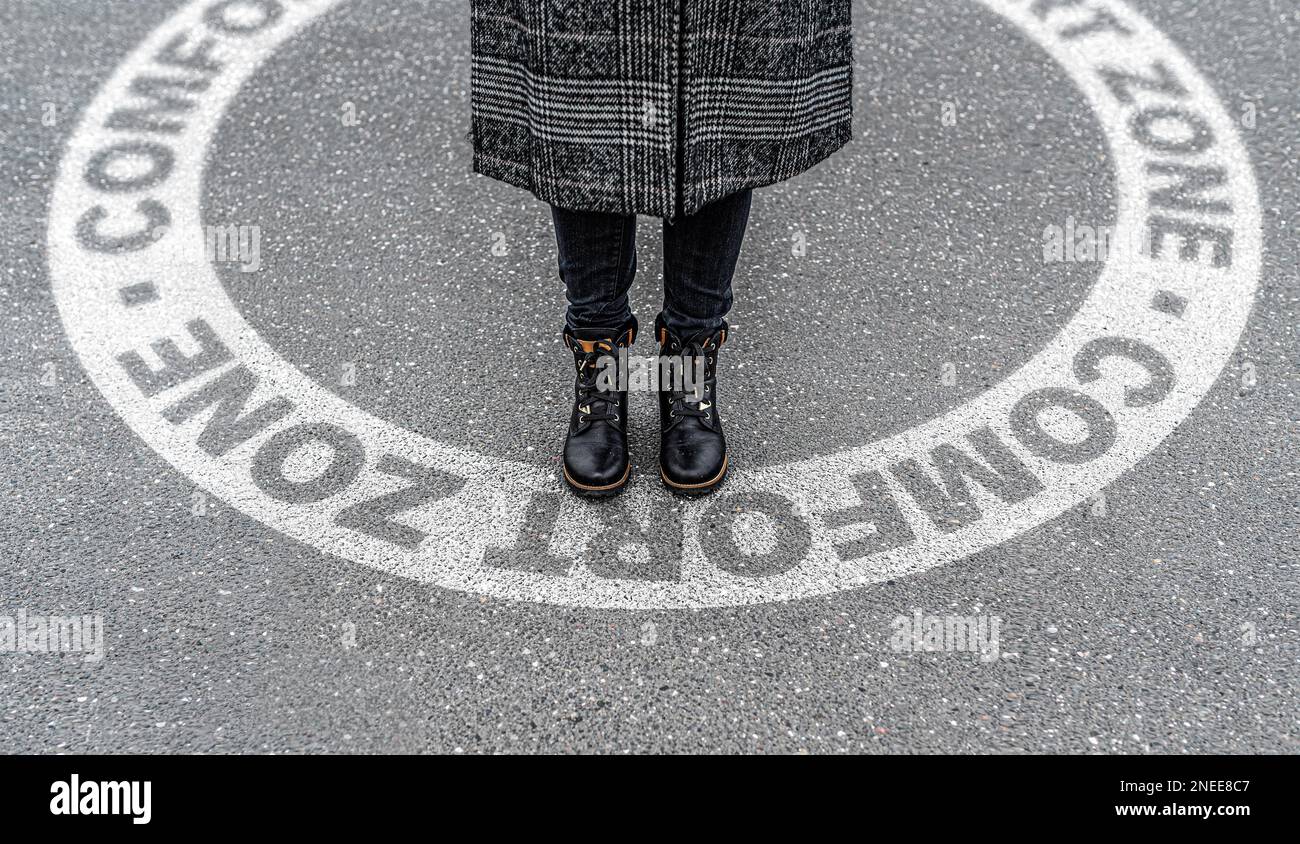 Portrait de jambes d'une femme sur le point de quitter le marquage circulaire sur l'asphalte appelée zone de confort Banque D'Images