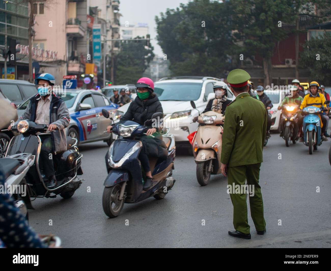 Un officier de l'armée en uniforme dirige un trafic important à Hanoi, Vietnam. Banque D'Images