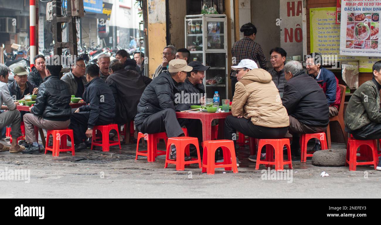 Un groupe d'hommes plaisantent et apprécient le café dans un café à Hanoi, Vietnam. Banque D'Images