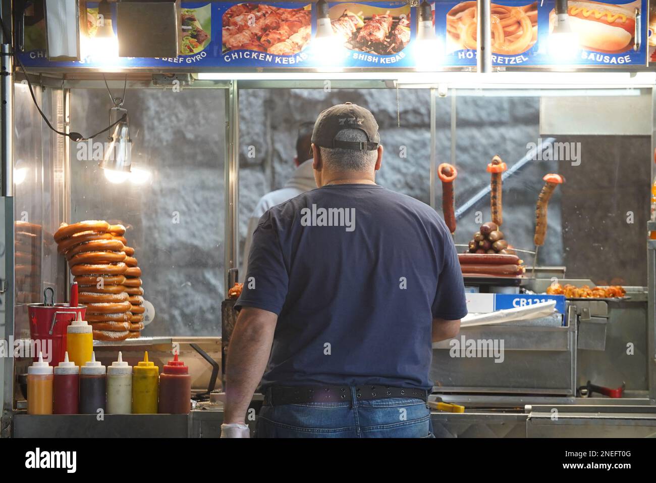 Un homme vend des hot dogs à partir d'un chariot alimentaire à Brooklyn, New York. Banque D'Images