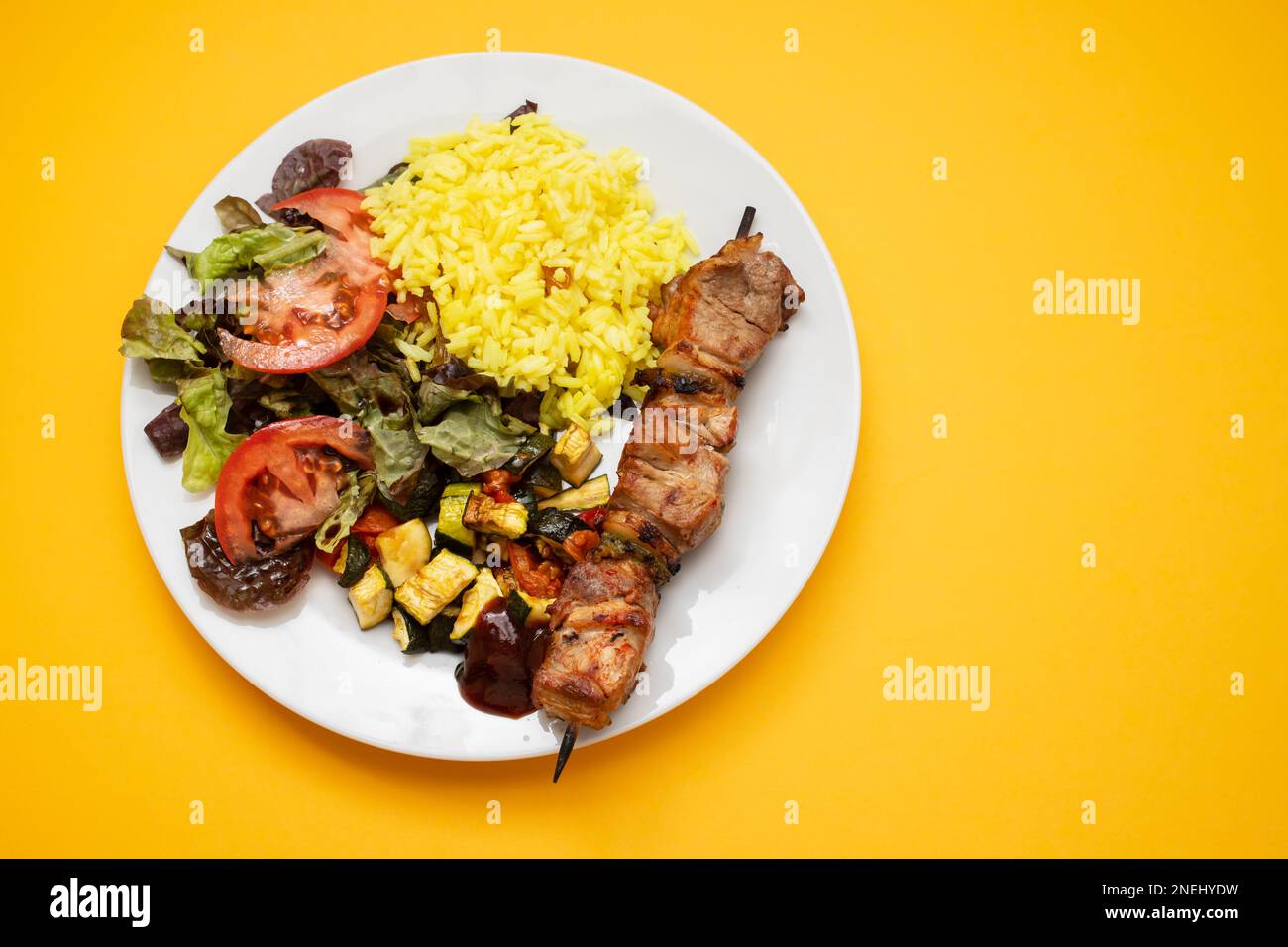 Viande grillée sur bâton, légumes, salade et riz bouilli sur l'assiette Banque D'Images