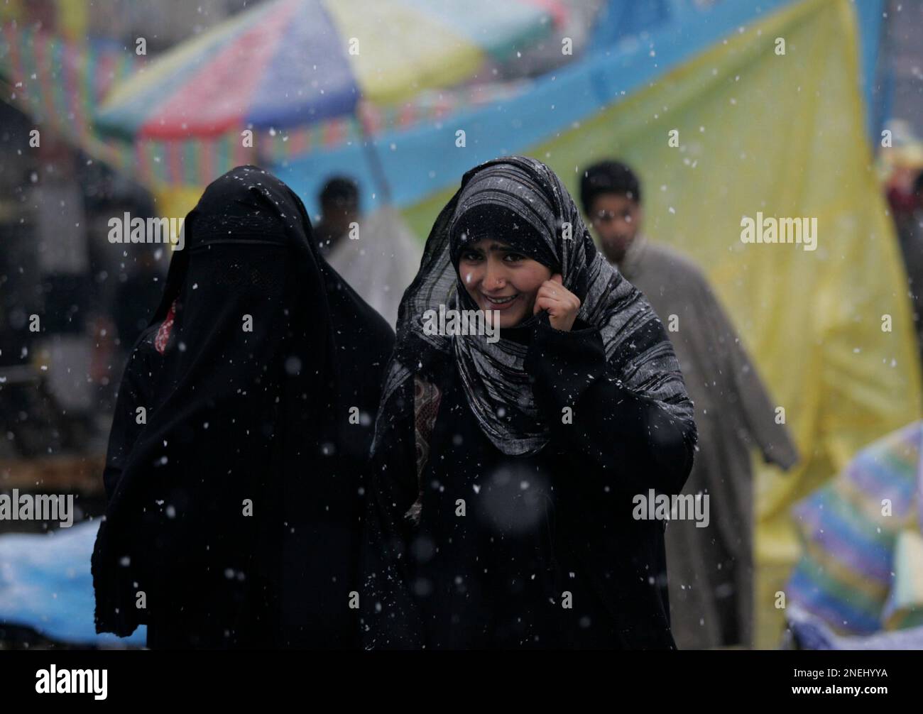 Kashmiri Muslim women walk during snowfall in Srinagar, India, Sunday, Jan. 3, 2010. The higher reaches of northern Indian states of Jammu Kashmir received snow while other parts of northern India suffered from cold wave conditions. (AP Photo/Mukhtar Khan) Banque D'Images