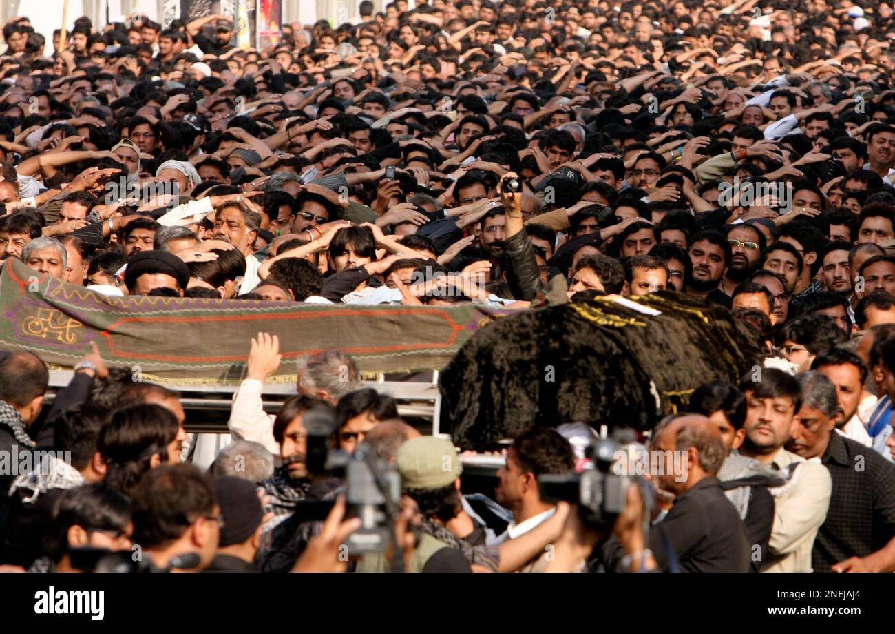 Pakistan Shiite Muslims carry coffins of the victims of Monday's suicide bombing as others chant religious slogans during a funeral prayer Tuesday, Dec. 29, 2009 in Karachi, Pakistan. Authorities appealed for calm Tuesday after a bombing against a Shiite Muslim procession killed 43 in Pakistan's largest city of Karachi, setting off riots and igniting fears of sectarian unrest. (AP Photo/Fareed Khan) Banque D'Images
