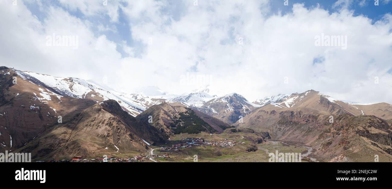 Paysage de montagne géorgien avec maoutains du Caucase et townlet Stepantsminda par une journée ensoleillée. Photo panoramique Banque D'Images