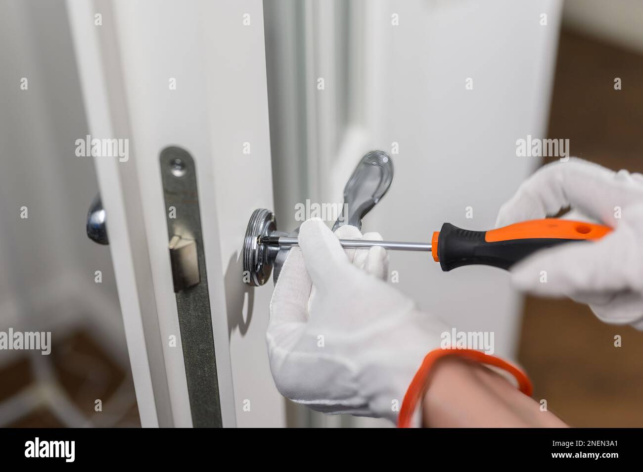 Fixation d'une poignée de porte ou d'un bouton de porte desserré. Fixation de la poignée de porte à l'aide de vis de réglage exposées Banque D'Images