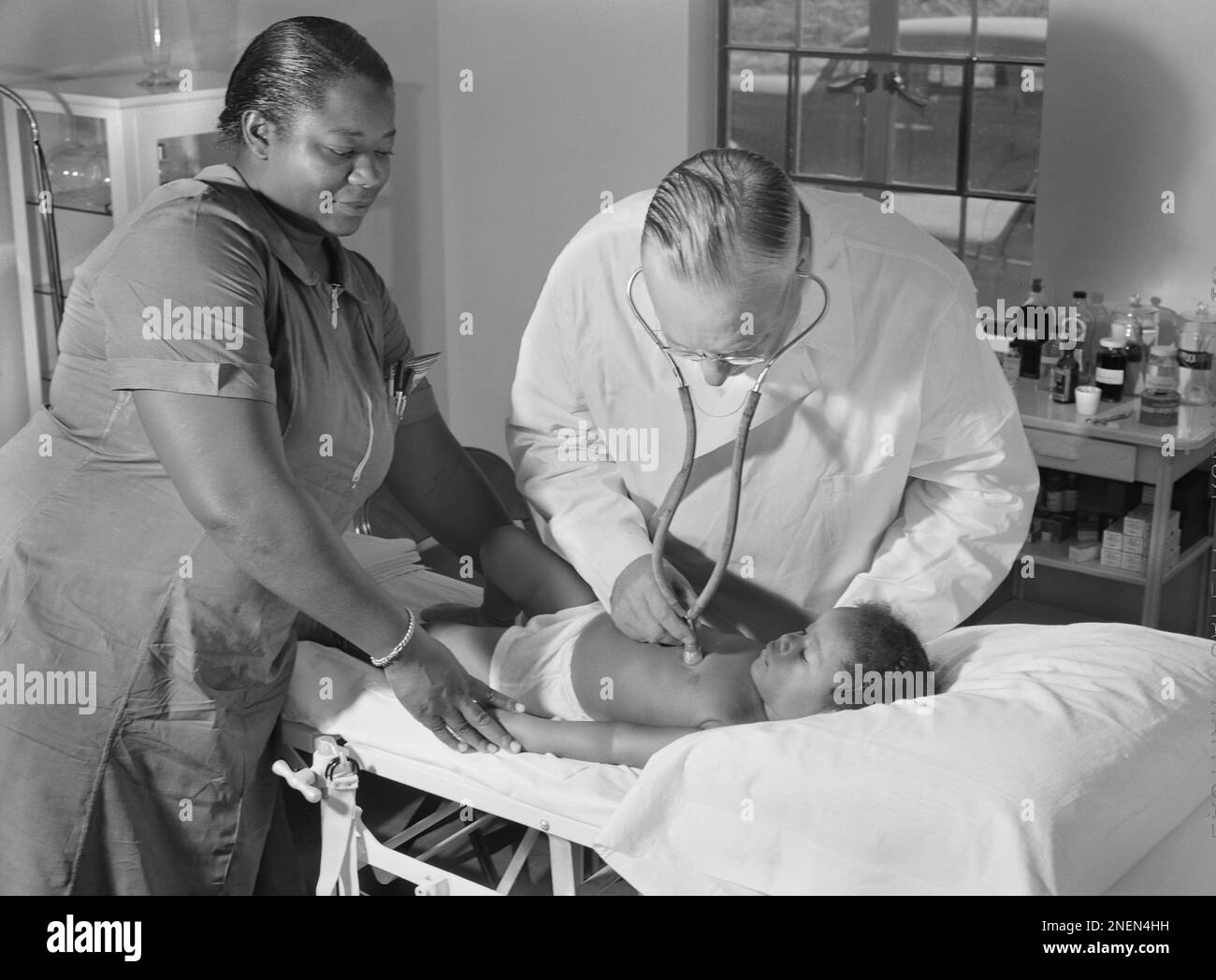 Le Dr William J. Buck examine l'enfant avec une infirmière de camp qui aide à la clinique, Okeechobee migration Labor Camp, Belle Glade, Floride États-Unis, Marion Post Wolcott, États-Unis Administration de la sécurité agricole, juin 1940 Banque D'Images