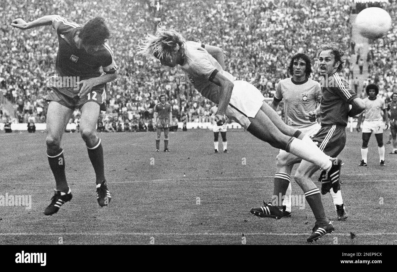 Poland's Kazimierz Deyna , left, heads the ball towards the Brazilian goalmouth, with Brazil's Marinho Chagas, right, missing the ball in the Football World Cup third place match between Poland and Brazil in Munich on July 6, 1974. In background Poland's Grzegorz Lato, right, and Carpegiani. Poland defeated Brazil 1-0. (AP Photo) Banque D'Images