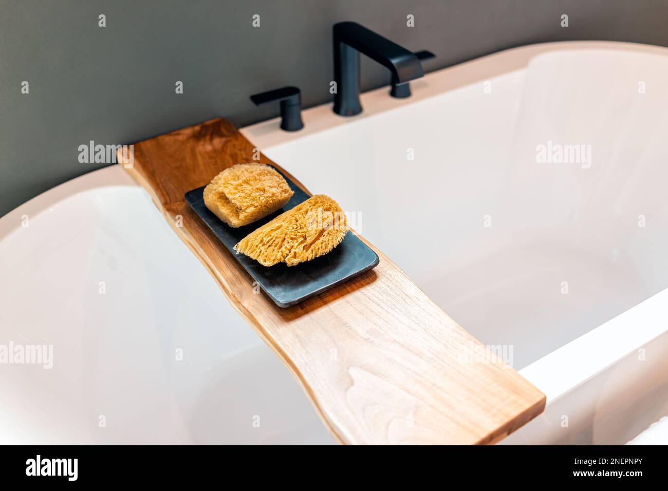 Baignoire étagère en bois berceau dans la salle de bains staging modèle maison avec éponge loofah épurateur dans la chambre blanche de luxe moderne Banque D'Images