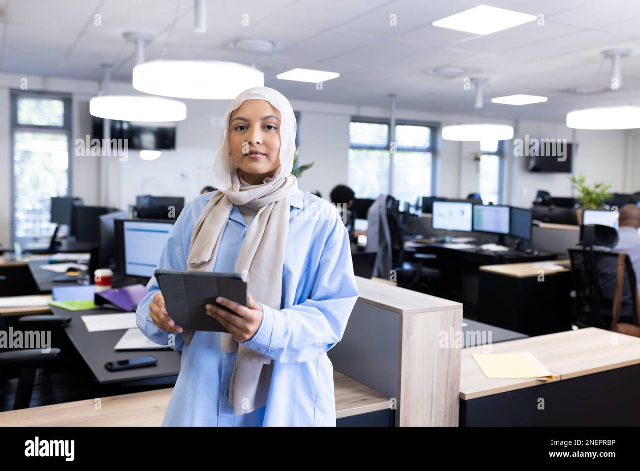 Une femme d'affaires sérieuse du Moyen-Orient dans le hijab regardant la caméra dans le bureau Banque D'Images