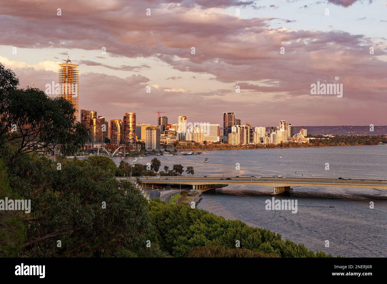 Vue sur le centre de Perth en Australie occidentale, paysage avec les gratte-ciels, les parcs et la baie avec le pont au coucher ou au lever du soleil. Nuages sur TH Banque D'Images