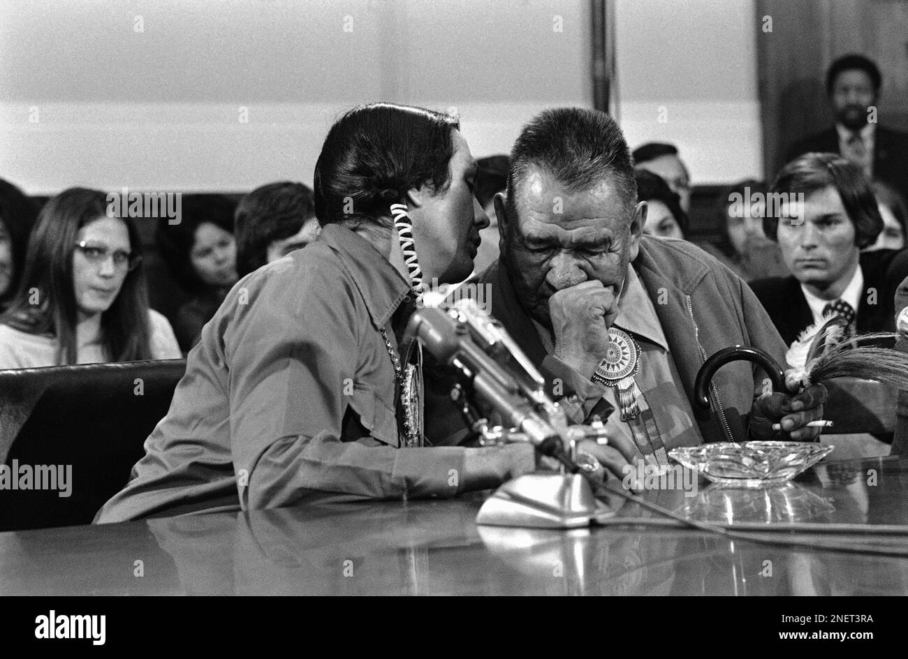 Russell Means, leader of the American Indian Movement, left, leans over for a few private words with Chief Terronez Bad Cob, Monday, April 9, 1973 during their appearance before the House Indian Affairs subcommittee in Washington. (AP Photo/Charles Gorry) Banque D'Images