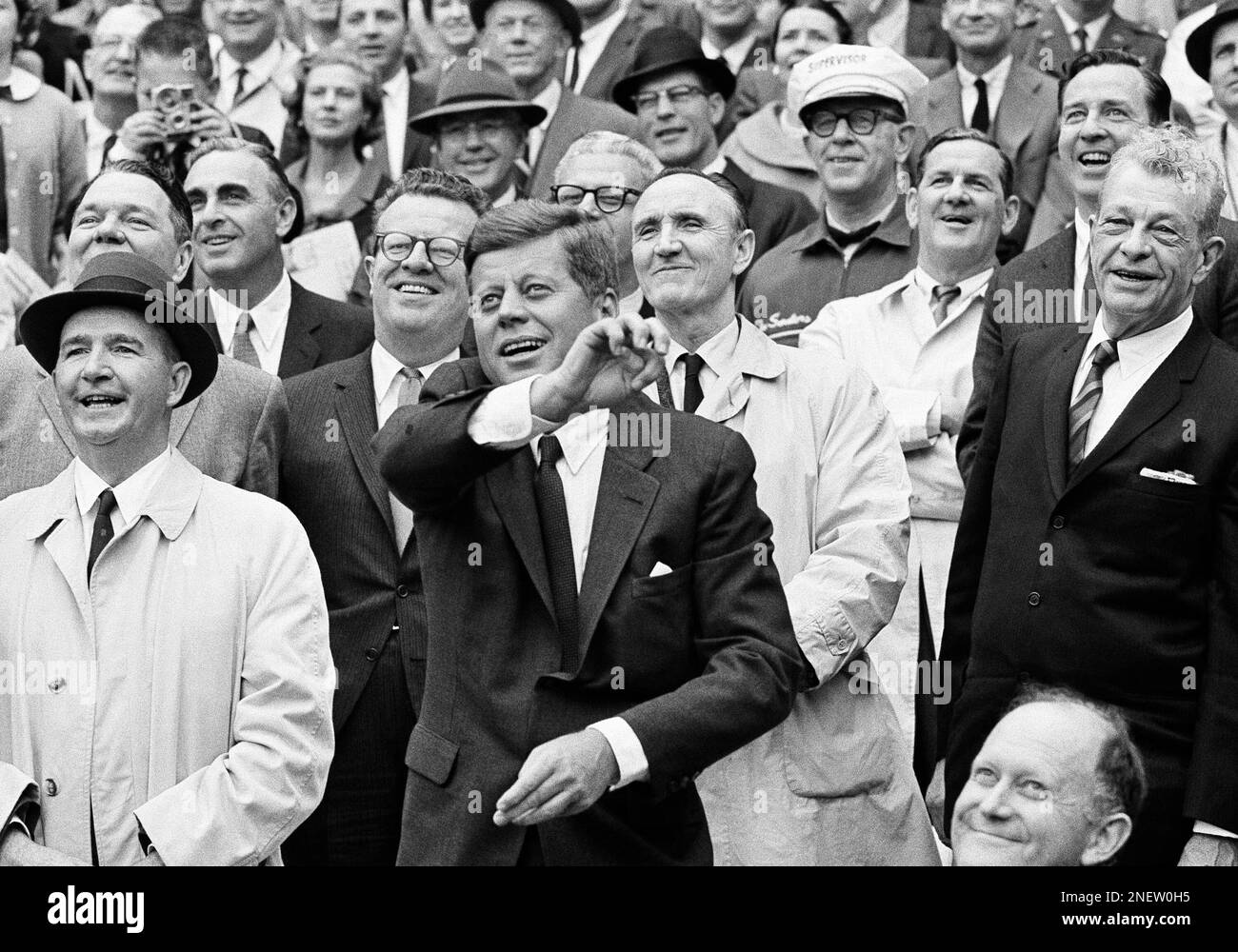 President John F. Kennedy sends out the first pitch which opens the American League baseball season, April 8, 1962, in Washington. In background, Lawrence O’Brien, left, presidential aide, and Sen. Mike Mansfield ( D-Mont.). Kennedy threw the ball from the presidential box in the new District of Columbia Stadium. Pitcher Marty Kutyna of Washington got the ball after a player scramble. (AP Photo) Banque D'Images