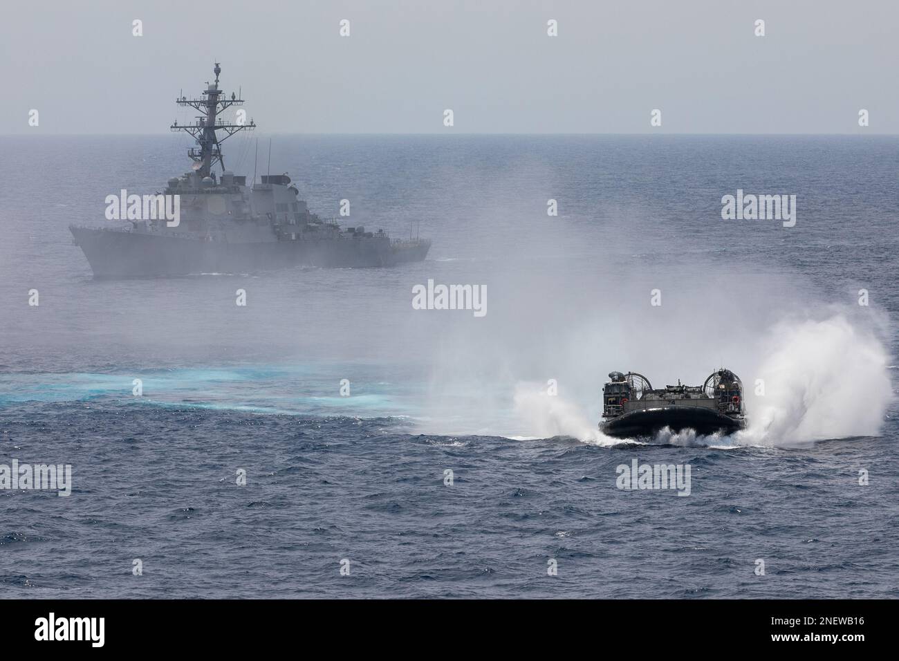 230215-N-AT895-1074 MER DE CHINE DU SUD (le 15 février 2023) Coussin d'air pour embarcation d'atterrissage (LCAC) de l'unité d'embarcation d'assaut (ACU) 5 manœuvres devant le destroyer à missiles guidés de la classe Arleigh Burke USS Decatur (DDG 73). Le Nimitz Carrier Strike Group (NIMCSG) et le Makin Island Amphiobie Ready Group (MKI ARG), avec l'unité expéditionnaire maritime embarquée 13th (MEU), mènent des opérations de force expéditionnaire combinée (ESF), démontrant une capacité de combat de haut niveau unique, une supériorité maritime, une projection de puissance et une préparation. Les opérations comprennent une formation intégrée conçue pour faire progresser l'interopérabilité Banque D'Images