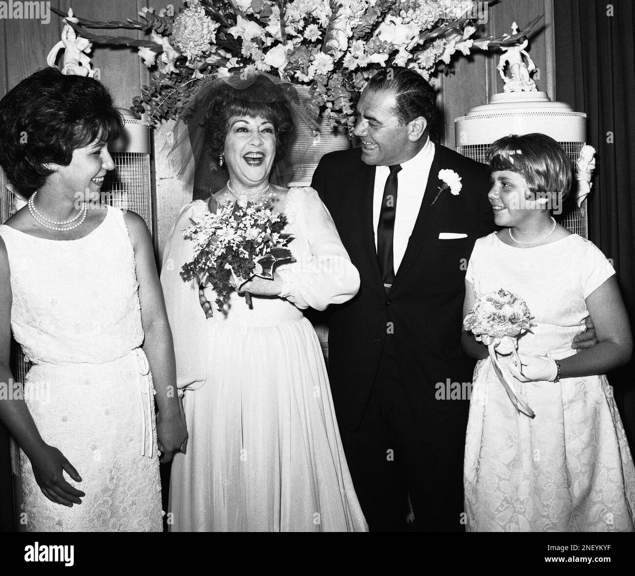 Singer Ethel Merman and actor Ernest Borgnine are all smiles at the Hollywood reception which followed their marriage in the garden of his home on June 27, 1964 in Hollywood. At left is Mrs. Ethel Geary, 21, Ethel Merman’s daughter by a previous marriage. At right is Nancy Borgnine, 12, Ernest Borgnine’s daughter by a previous marriage. (AP Photo/Harold Matosian) Banque D'Images