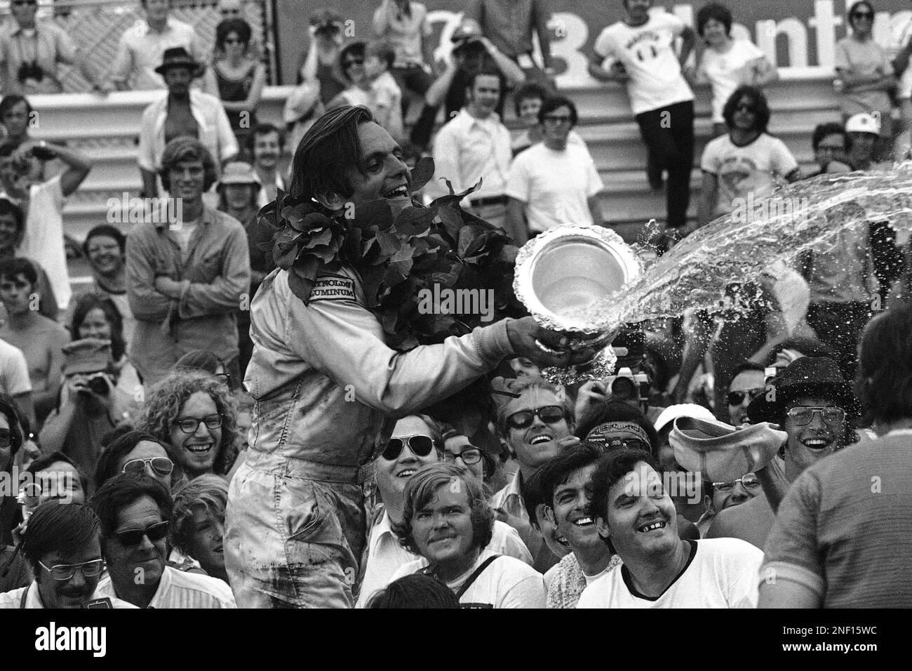 Peter Revson, winner of the Can-Am Challenge Cup race at Watkins Glen race course, New York douses the crowd with champagne in the winners circle after the event, July 25, 1971. Revson drove the 199-mile race at an average speed of 128:58 miles per hour. He makes his home in New York City. (AP Photo) Banque D'Images