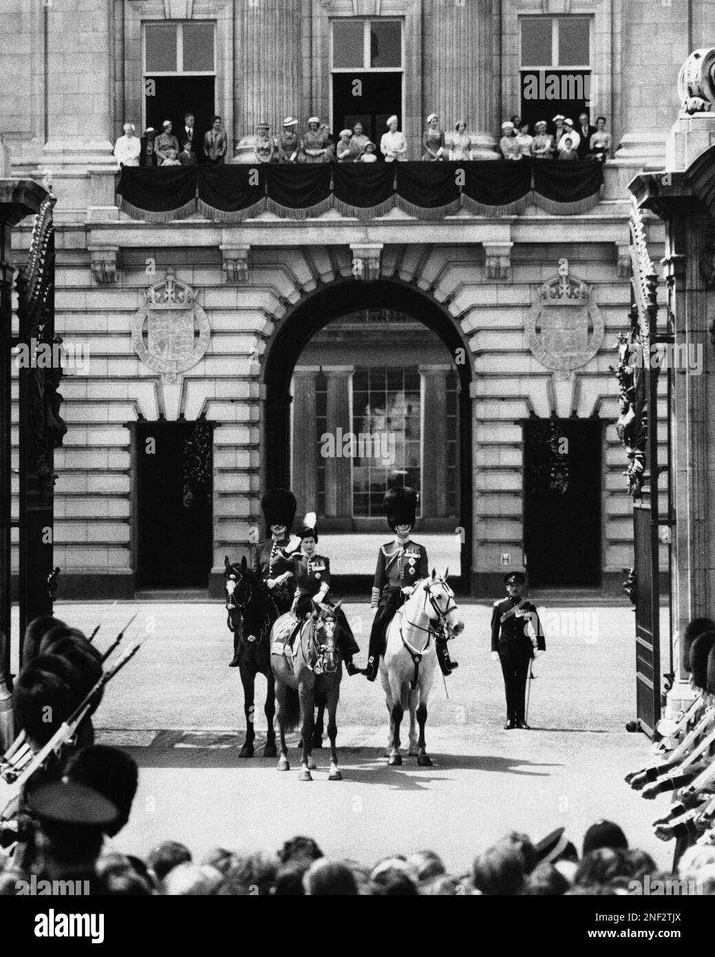 Queen Elizabeth II returns salute at Buckingham Palace Gate in London, England, during trooping of the color ceremony May 31, 1956, her official birthday. At left is the Duke of Gloucester, and at right is the Duke of Edinburgh. Members of the Royal family including the Queen Mother are on balcony in background. (AP Photo) Banque D'Images