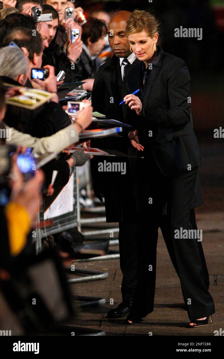 U.S. actress Julia Roberts, center, signs autographs for fans as she arrives for the world premiere of the film Duplicity in London, Tuesday, March 10, 2009. (AP Photo/Sang Tan) Banque D'Images