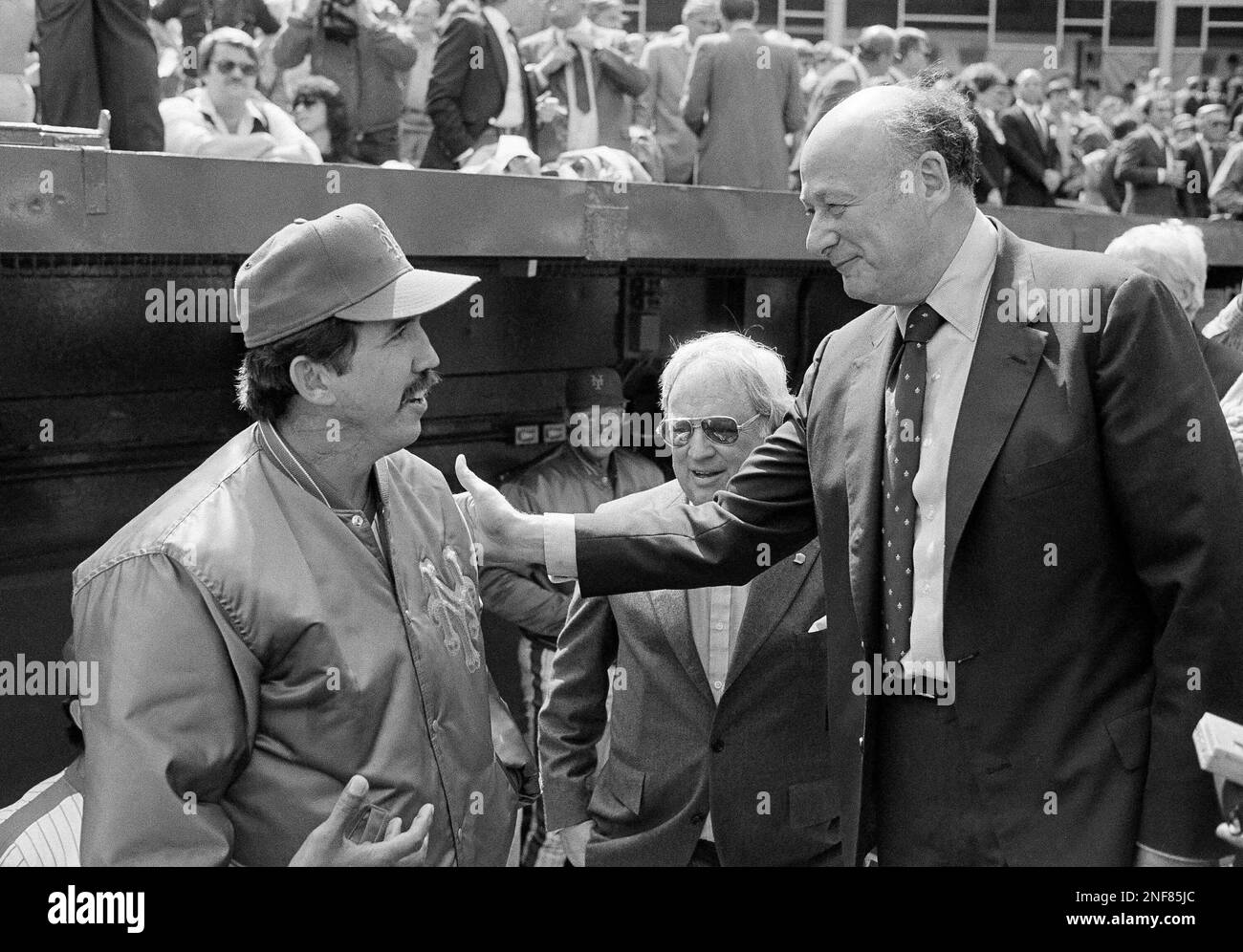 New Yorks Mayor Ed Koch, right, says hello to New York Manager Dave Johnson, left, and General Manager Frank Cashen, center, before the opening day ceremonies at Shea Stadium, April 17, 1984, New York. Thats former manager Frank Howard at center rear. The Expos from Montreal spoiled the opener, beating the Mets 10-0. (AP Photo/Richard Drew) Banque D'Images