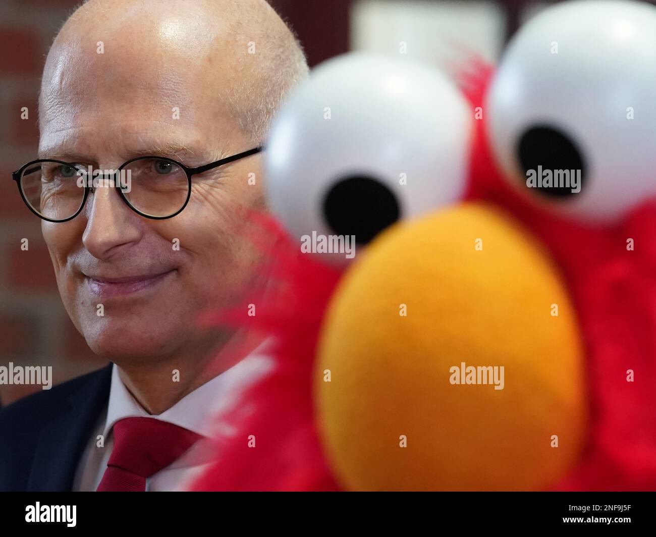 Hambourg, Allemagne. 16th févr. 2023. Peter Tschentscher (SPD), premier maire et président du Sénat de la ville libre et hanséatique de Hambourg, se dresse à côté du personnage de la rue Sesame Elmo lors de l'ouverture de l'exposition "50 ans de la rue Sesame Allemagne - plus qu'un spectacle TV" au Musée de l'émigration Ballinstadt. L'exposition présente des marionnettes, des accessoires et des costumes de cinq décennies de 'Sesame Street', qui a été co-produit en Allemagne par Sesame Workshop et Norddeutscher Rundfunk (NDR) depuis 1973. Credit: Marcus Brandt/dpa - ATTENTION: Utiliser seulement en format complet/dpa/Alamy Live News Banque D'Images