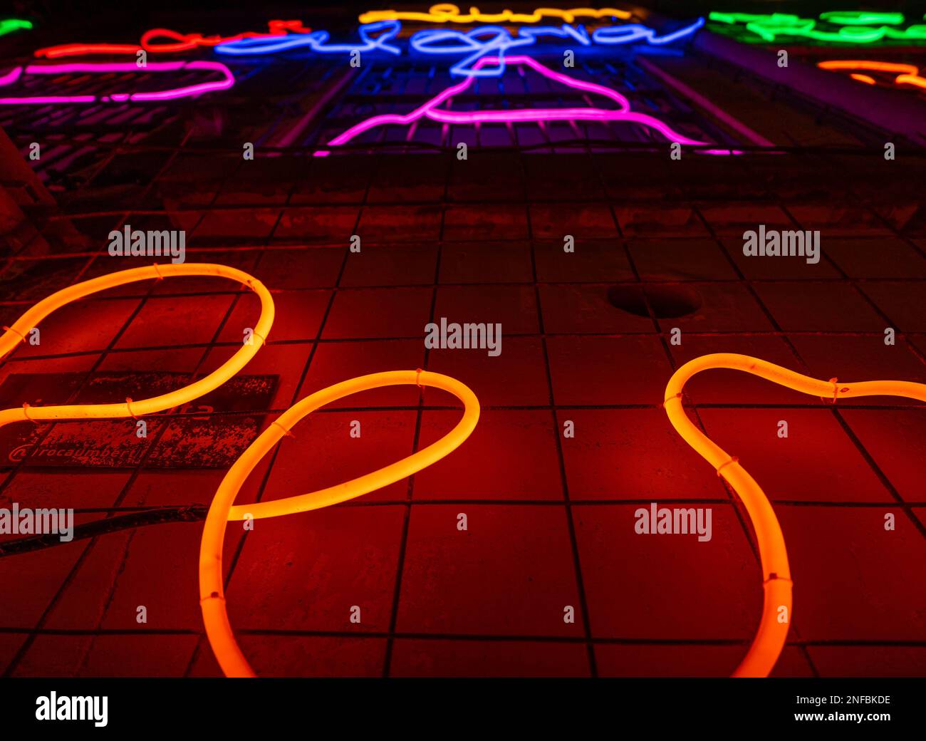 Lettres et mots lumineux fabriqués avec des néons et des LED de plusieurs couleurs avec un point de fuite en arrière-plan. Fils et tubes liés à créer Banque D'Images