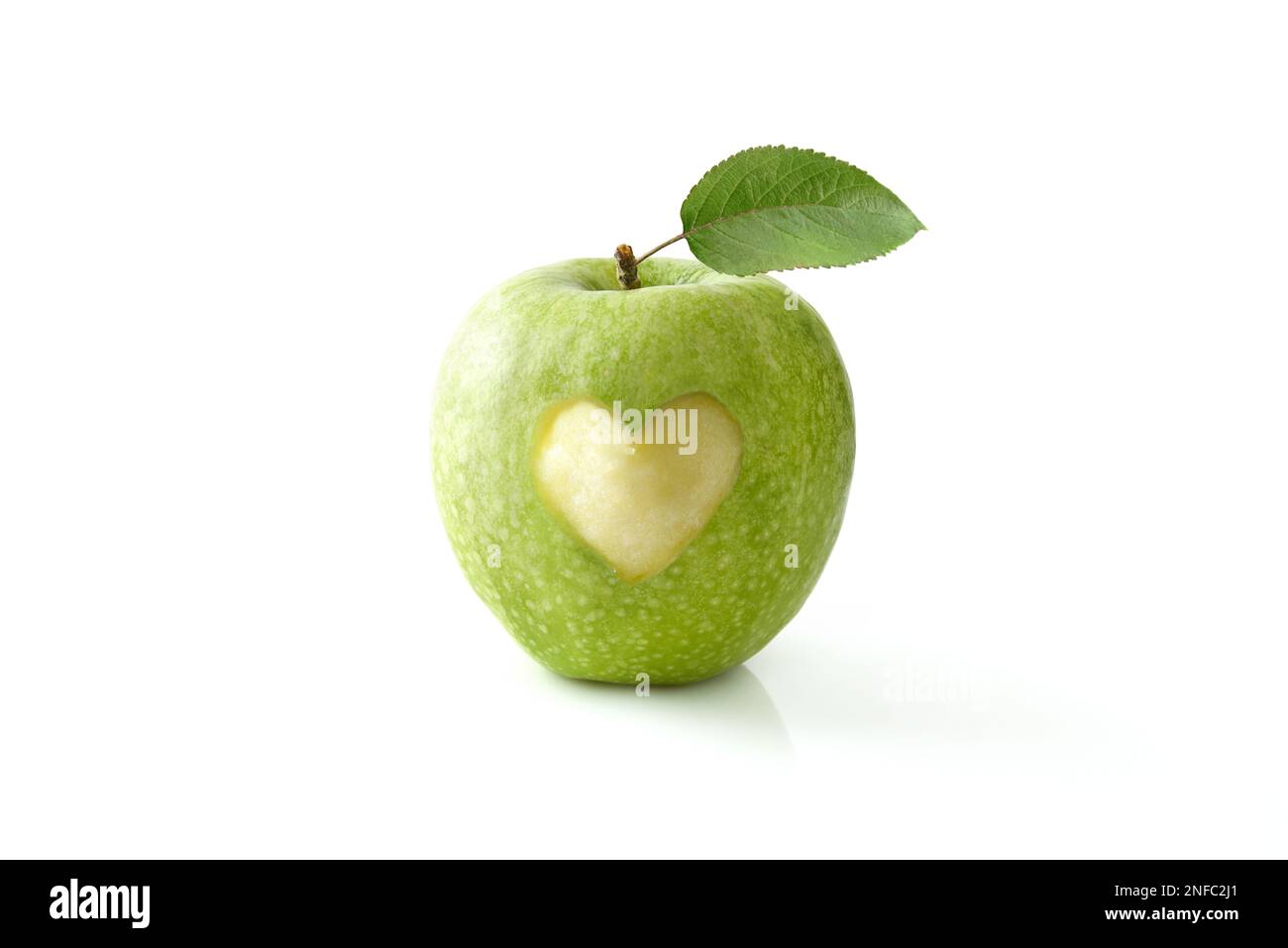Pomme verte mangée au centre avec une forme de coeur reflétée sur la table blanche et le fond isolé. Vue avant. Banque D'Images