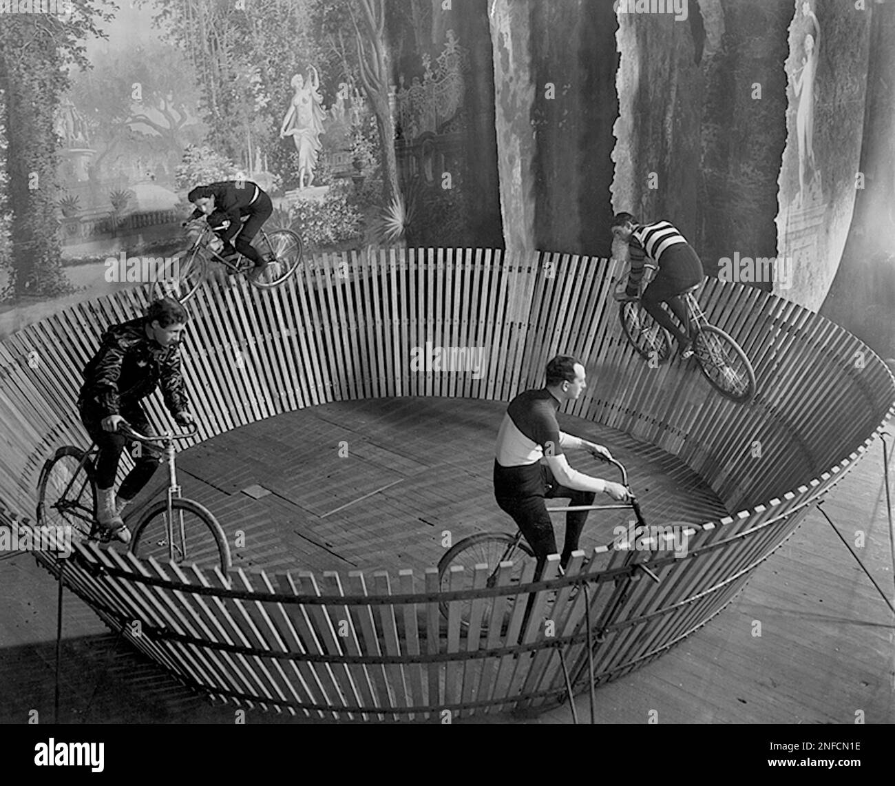 Aller nulle part vite - la force centrifuge maintient ces cyclistes du diable debout - 1901 Banque D'Images
