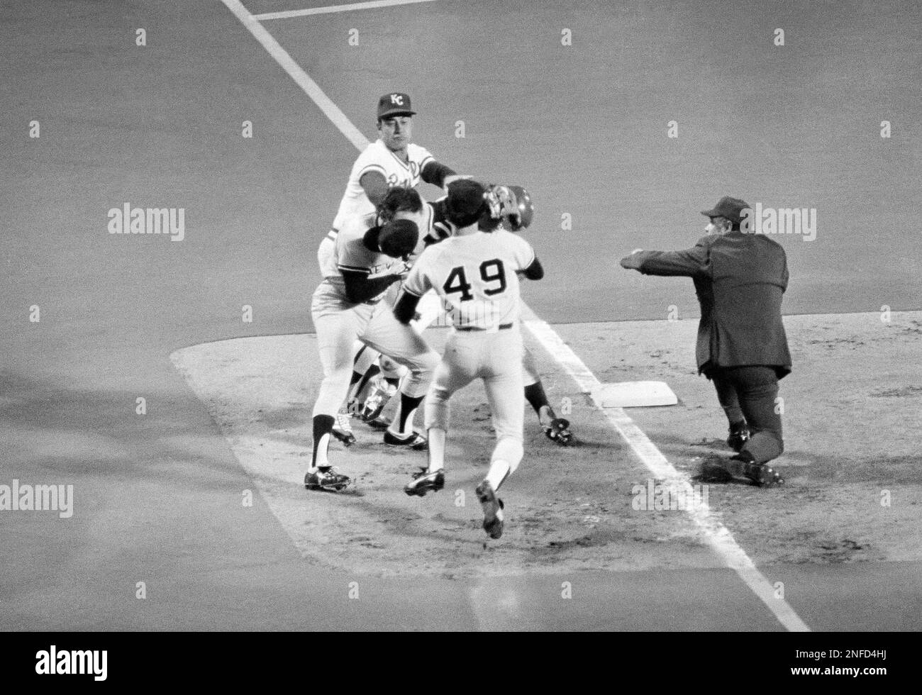 George Brett, Royals third sacker, comes up swinging at his Yankees counterpart Graig Nettles (9) after belting a run-producing triple in first inning of final American League playoff game in Kansas City, Oct. 9, 1977. Umpire is Marty Springstead, right, Ron Guidry (49) Yankee pitcher, watches as Royals coach Chuck Hiller, top left, tries to break up the scuffle. Both benches went to the scene but the scuffle was broken up. (AP Photo) Banque D'Images