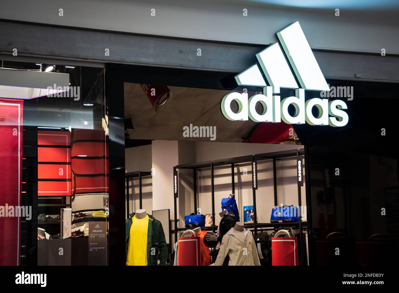 Entrée du magasin Adidas avec logo dans un centre commercial. Adidas AG est un fabricant allemand de vêtements de sport en Europe. Budapest, Hongrie - 3 février 2023. Banque D'Images