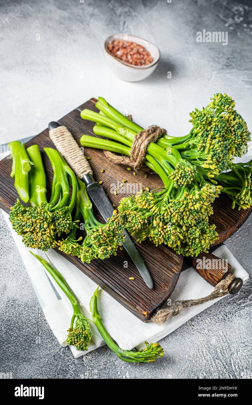 Bouquet frais de broccolini pousses sur le plan de coupe prêt pour la cuisine. Arrière-plan blanc. Vue de dessus. Banque D'Images