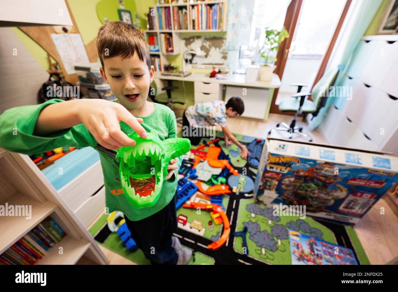 Ternopil, Ukraine - février, 2023: Les enfants unboxing Hot Wheels City Ultimate  garage, jouer dans la chambre des enfants. Garçon tient un gros dinosaure  vert Photo Stock - Alamy