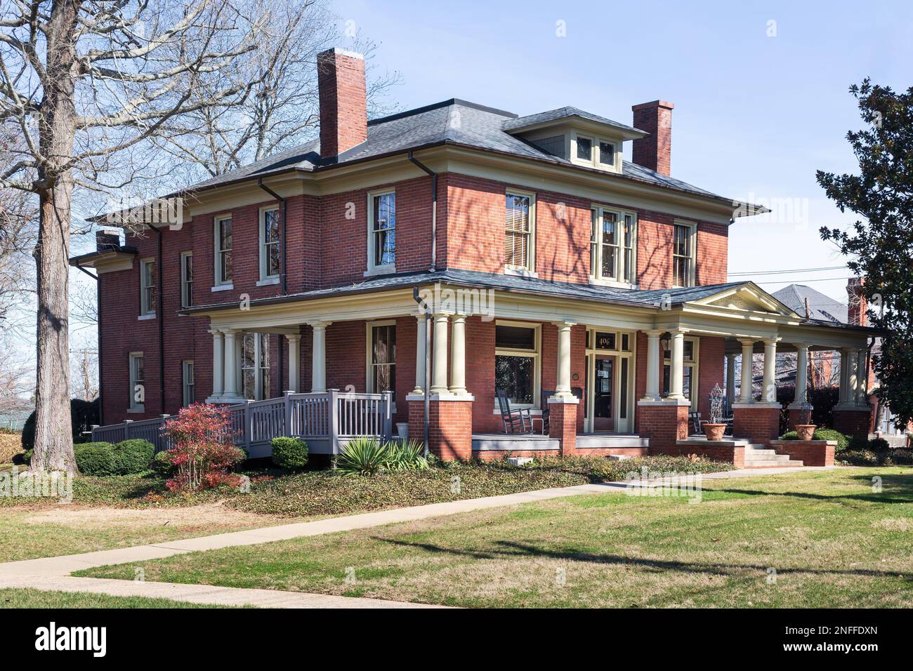 HICKORY, NC, USA-14 FEB 2023: Maison grecque en brique de style renouveau avec porche enveloppant dans la communauté d'Oakwood, servant de bureaux pour Stifel Brokerage et Banque D'Images
