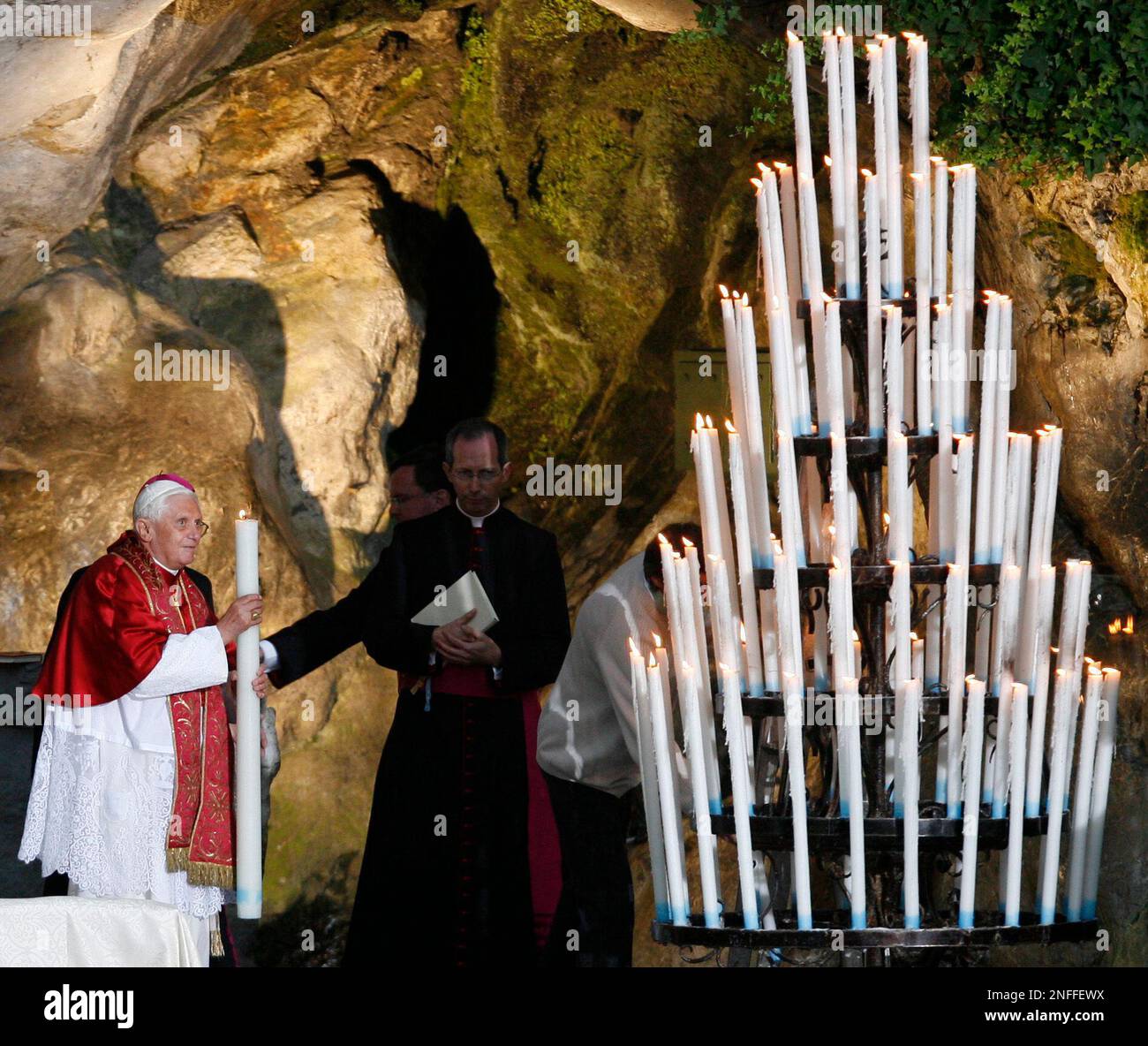Pope Benedict XVI holds a candle in the the Massabielle cave in Lourdes, southwestern France, Saturday, Sept. 13, 2008. The pontiff celebrated the 150th anniversary of apparitions of the Virgin Mary to local 14-year-old girl, Bernadette Soubirous. The shrine draws 6 million people annually, some of them disabled or desperately sick, many of them hoping for a miracle. (AP Photo/Alessandra Tarantino) Banque D'Images
