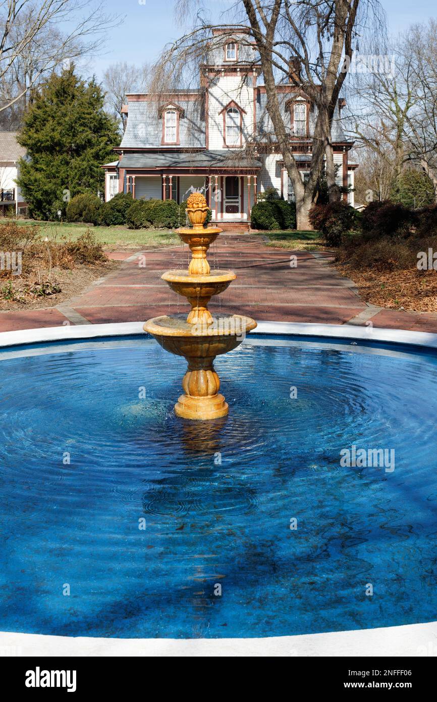 HICKORY, NC, USA-14 FÉV 2023: Fontaine dans le jardin commémoratif de Shuford avec le cottage Propst en arrière-plan, un second Empire français design, fonctionnant comme Banque D'Images
