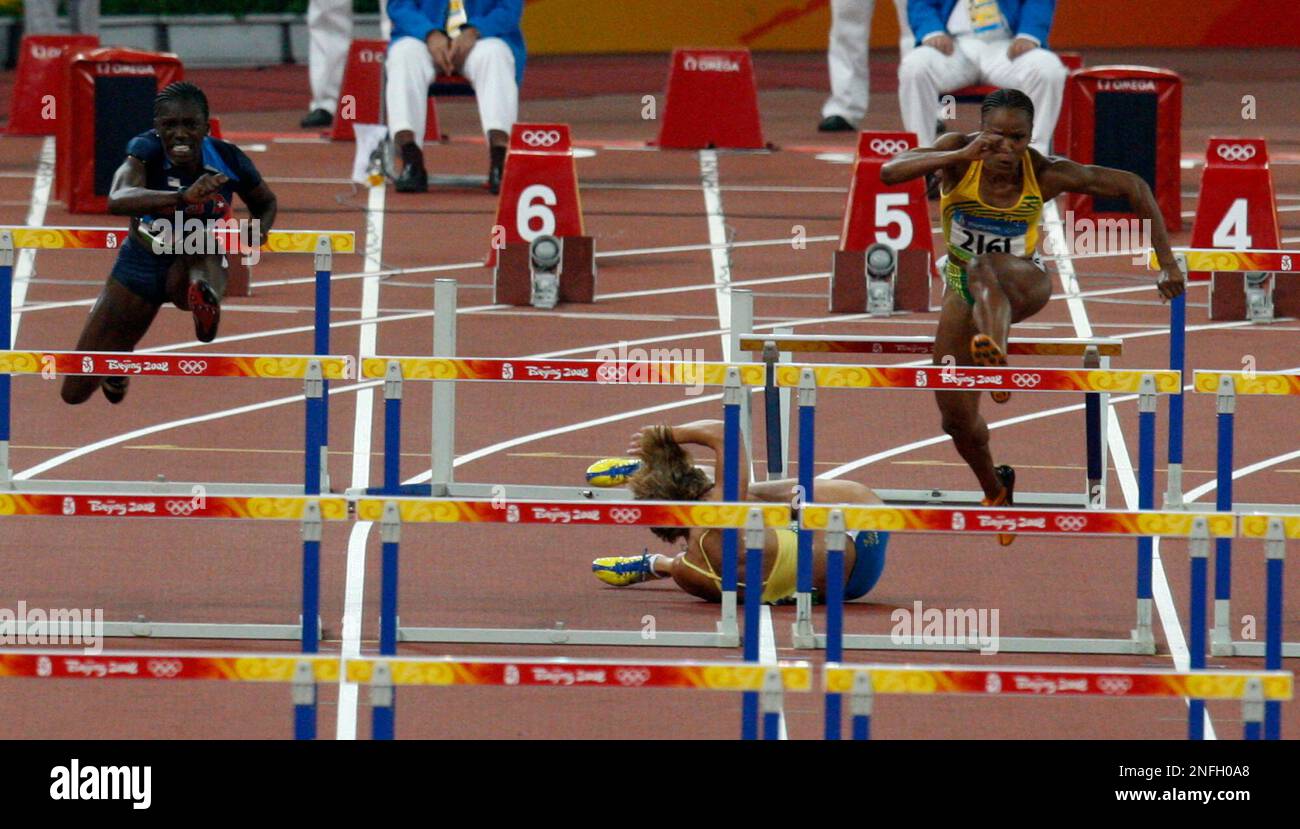 Sweden's Susanna Kallur, center, stumbles in a women's 100-meter hurdles semi-final during the athletics competitions in the National Stadium at the Beijing 2008 Olympics in Beijing, Monday, Aug. 18, 2008. At left is United States' Dawn Harper and at right is Jamaica's Vonnette Dixon. (AP Photo/Kevin Frayer) Banque D'Images