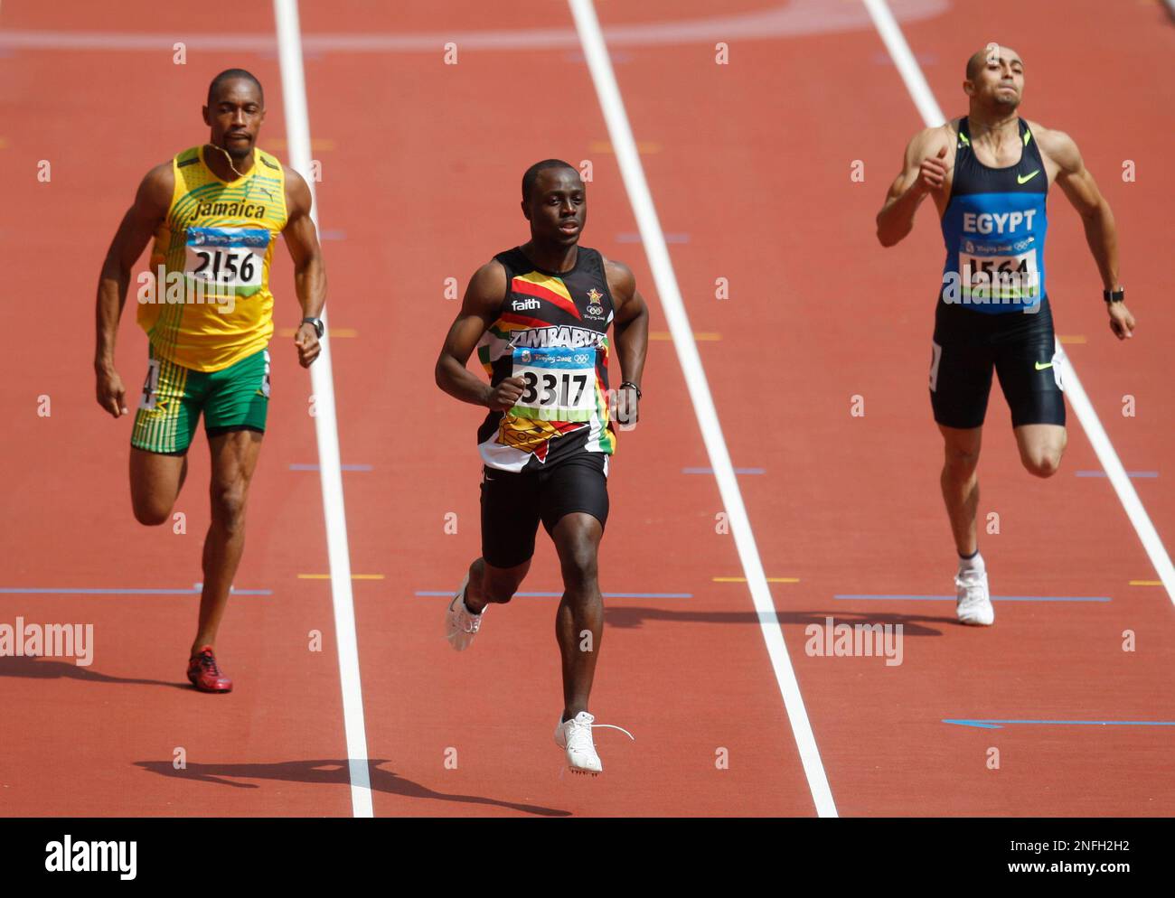 Zimbabwe's Brian Dzingai, center, Christopher Williams of Jamaica, left, and Amr Seoud of Egypt compete in a heat of the men's 200-meter during the athletics competitions in the National Stadium at the Beijing 2008 Olympics in Beijing, Monday, Aug. 18, 2008. (AP Photo/Kevin Frayer) Banque D'Images