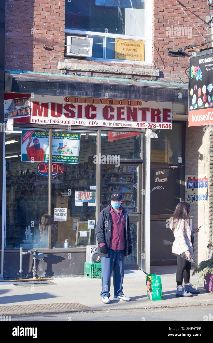 Toronto, Ontario, Canada-, 8 février 2023 : deux personnes se tenant devant un magasin de musique et de cinéma Bollywood. Banque D'Images