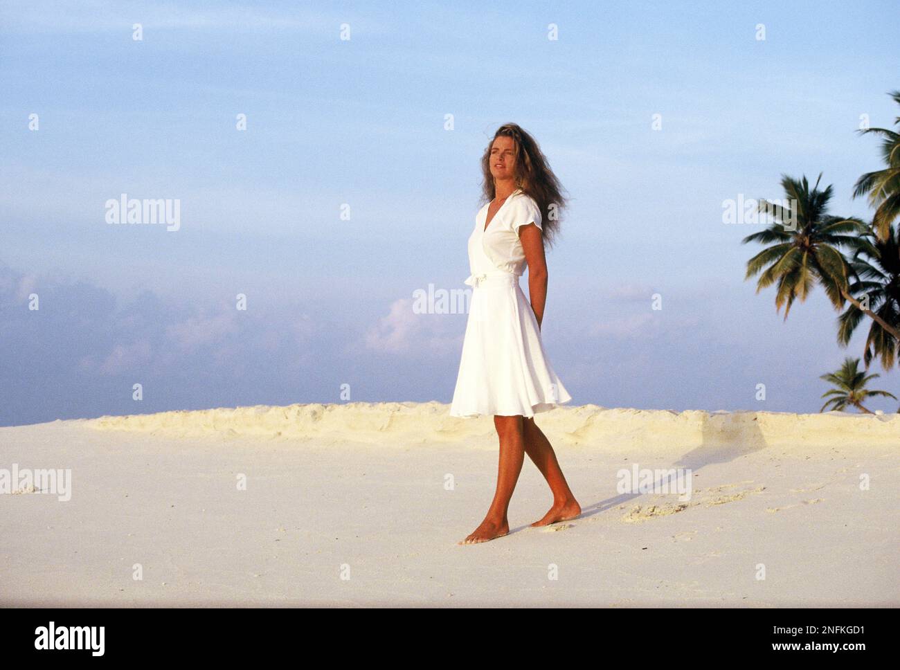 Maldives. Jeune femme debout sur la plage tropicale. Banque D'Images