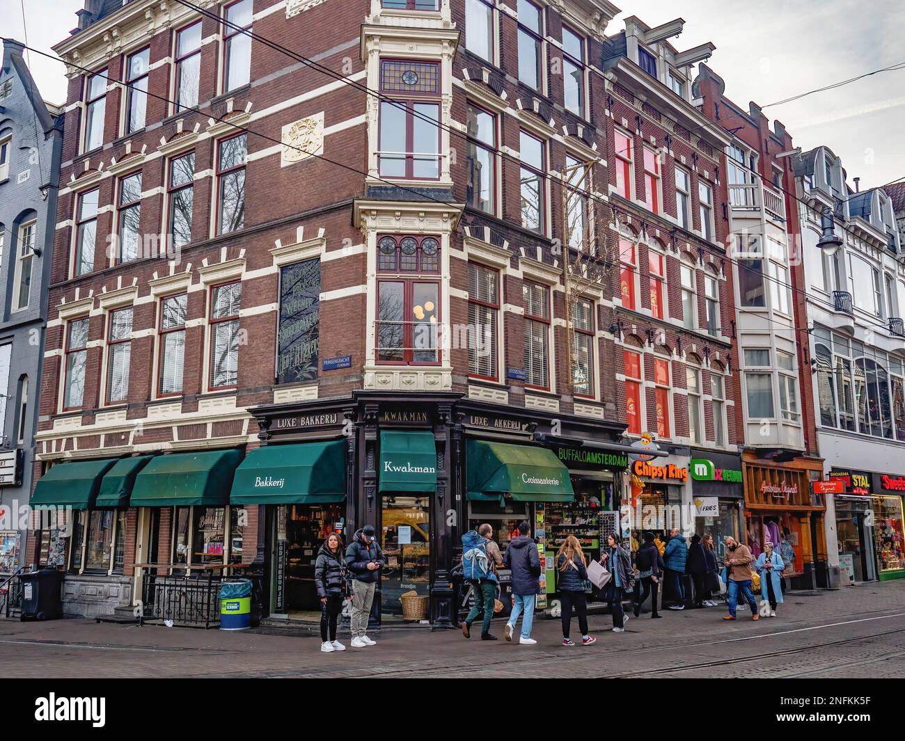 Les touristes sont vus profiter de la journée et aller faire du shopping dans le centre-ville. Amsterdam est l'une des villes les plus belles, les plus créatives et les plus favorables aux cycles en Europe. Il a un grand mélange d'une ambiance cosmopolite et d'une taille relativement petite, ce qui signifie qu'il y a un charme de village. Bien qu'il soit encore froid mais ensoleillé, les touristes visitent déjà la capitale néerlandaise en semaine. Les endroits les plus visités sont généralement la place du Dam, le centre-ville, les musées et les canaux. Banque D'Images