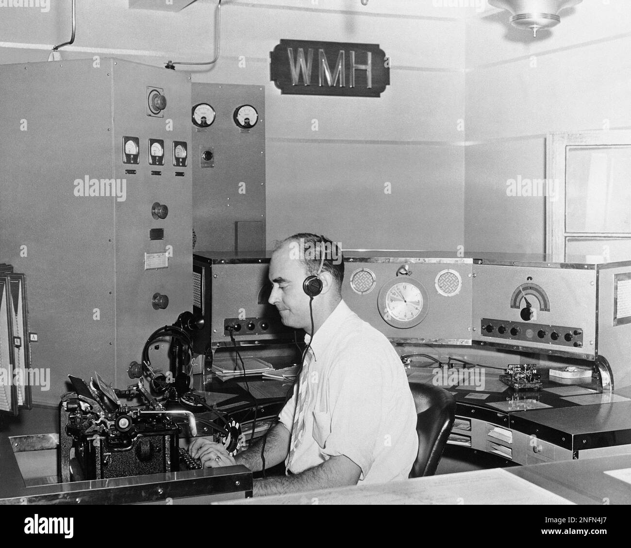 In contact with a ship at sea, Joseph R. Lawler taps out a message from radio station WMH on a municipal pier in Baltimore, Oct. 22,1956 . Lawler is one of six operators who man the station 24 hours a day, receiving and sending messages to and from merchantmen and their shipping companies. It is the United States' only municipally owned marine radio station. The city of Baltimore supplies the station's space and operators. The station makes no money, but its activities are considered important to the port. (AP Photo) Banque D'Images