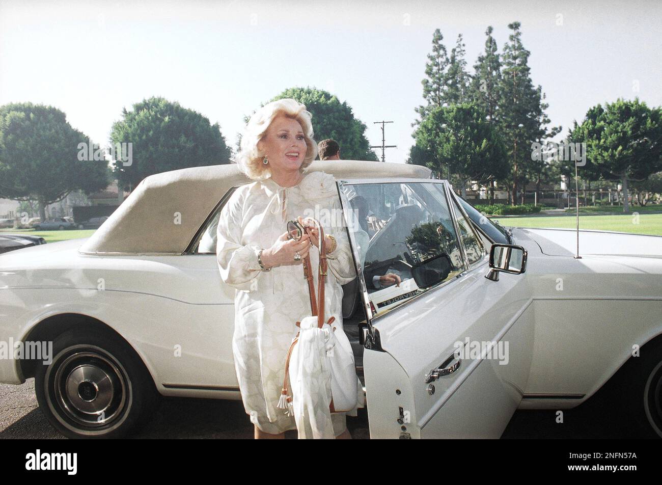 Alighting from what she described as her "Jailhouse Rolls-Royce," Zsa Zsa Gabor arrives on Sep. 14, 1989 at Beverly Hills Municipal Court for the first day of opening arguments of her trial for allegedly slapping a policeman in Beverly Hills. She wore a five year old Italian-designed cream-colored dress, and told a throng of reporters she didn't want to go to jail. "I am very easygoing. I don't want to go to prison. I have claustrophobia." (AP Photo/Nick Ut) Banque D'Images