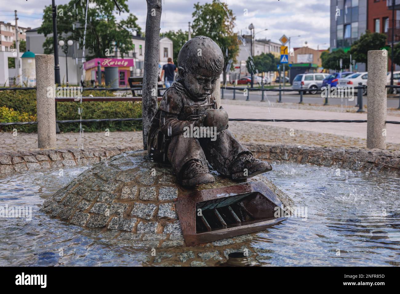 Garçon avec une fontaine aux pommes dans la ville de Skierniewice, province de Lodz en Pologne Banque D'Images