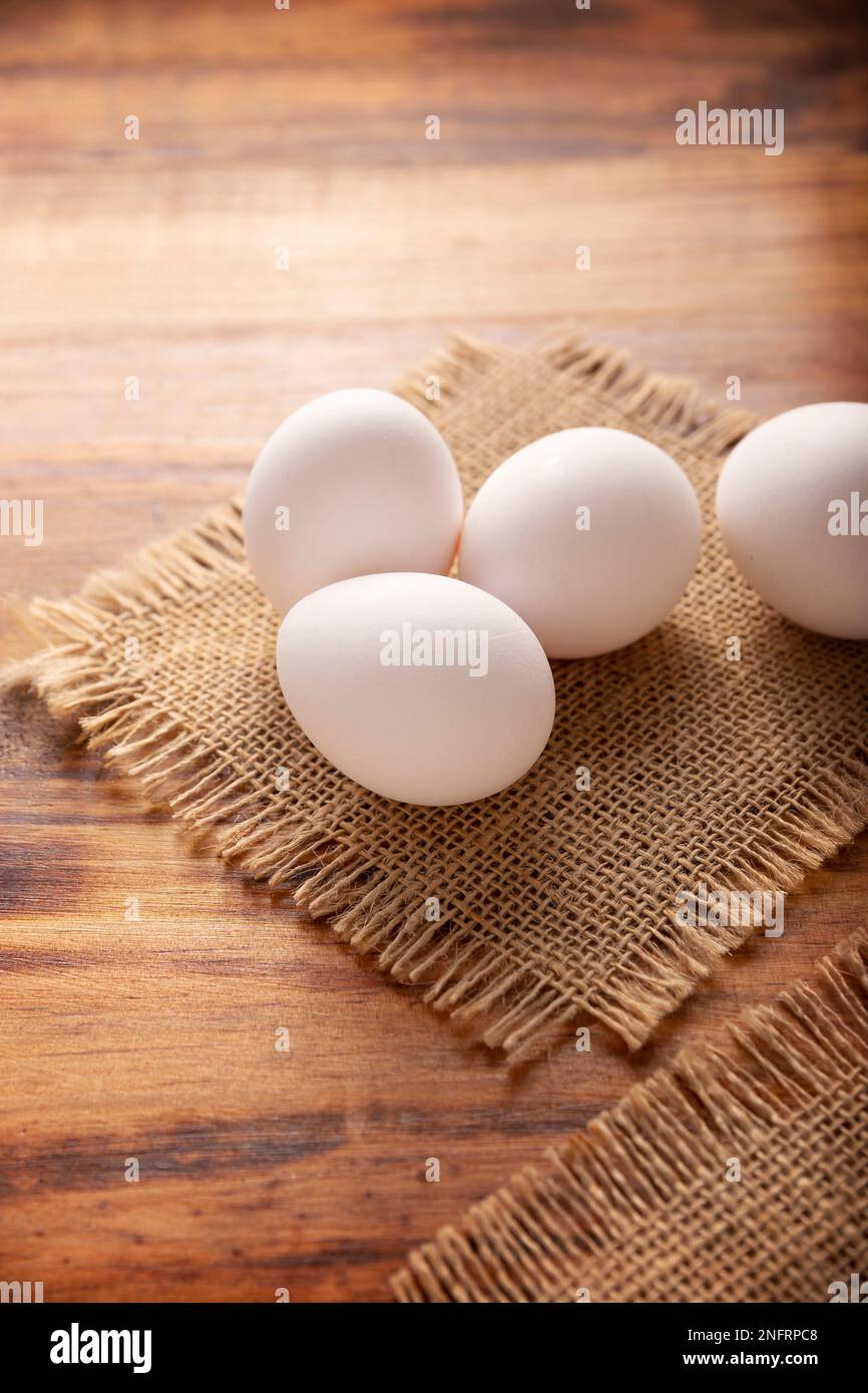 De nombreux œufs de poulet blancs sur une table rustique en bois. Produit alimentaire nutritif et économique très populaire. Banque D'Images