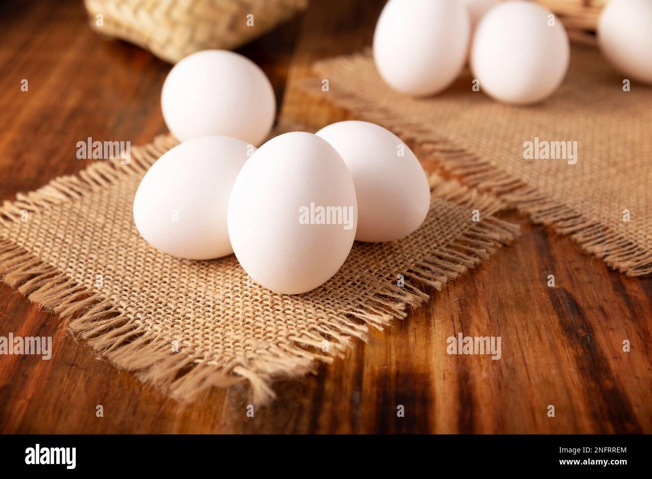 De nombreux œufs de poulet blancs sur une table rustique en bois. Produit alimentaire nutritif et économique très populaire. Gros plan. Banque D'Images
