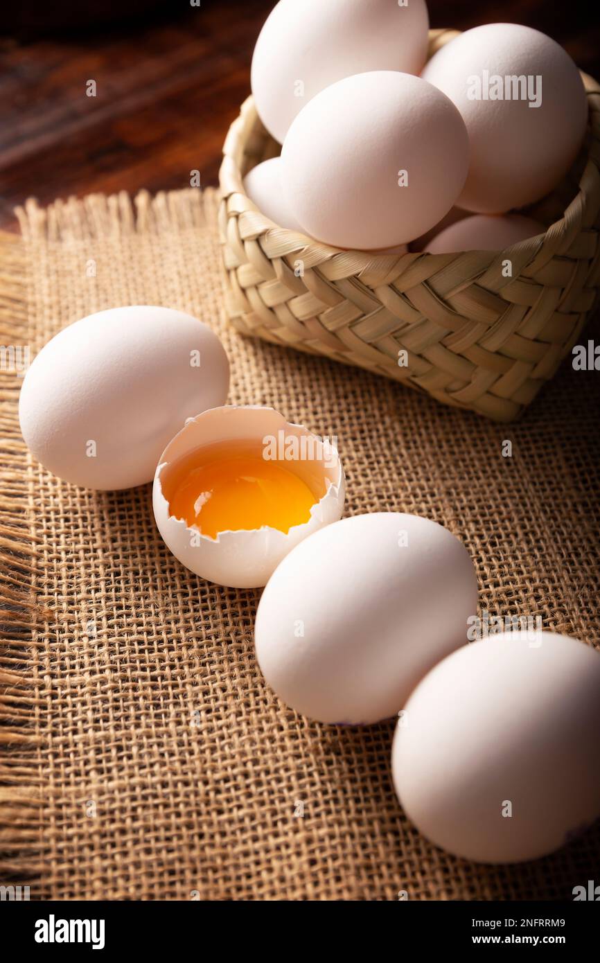 De nombreux œufs de poulet blancs sur une table rustique en bois. Produit alimentaire nutritif et économique très populaire. Banque D'Images