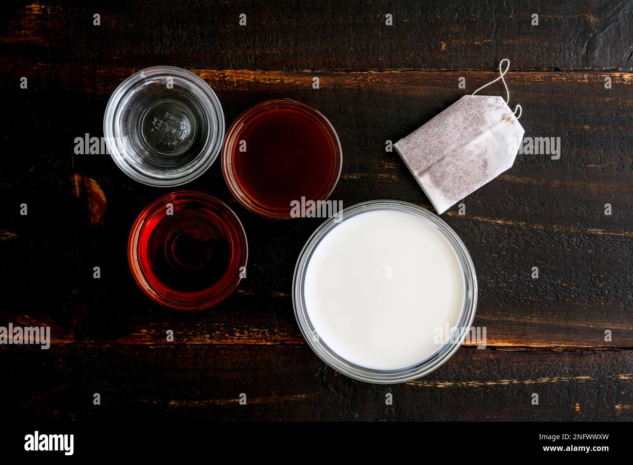 Rooibos thé Latte Ingrédients sur une table en bois : sachet de thé Rooibos, lait et autres ingrédients sur fond de bois foncé Banque D'Images