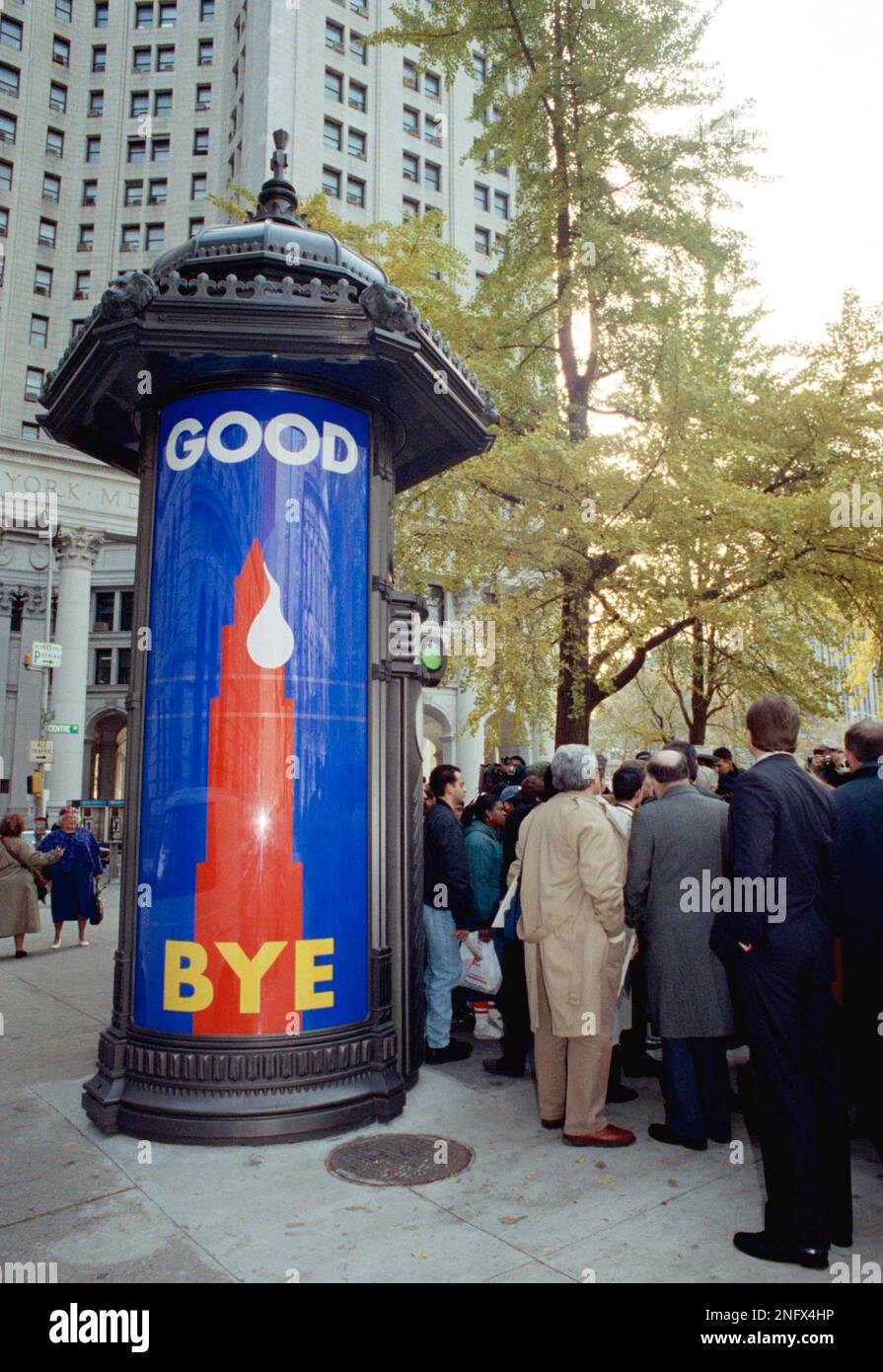 A crowd gathers near a public toilet kiosk on Chambers Street in Lower Manhattan Tuesday, Nov
