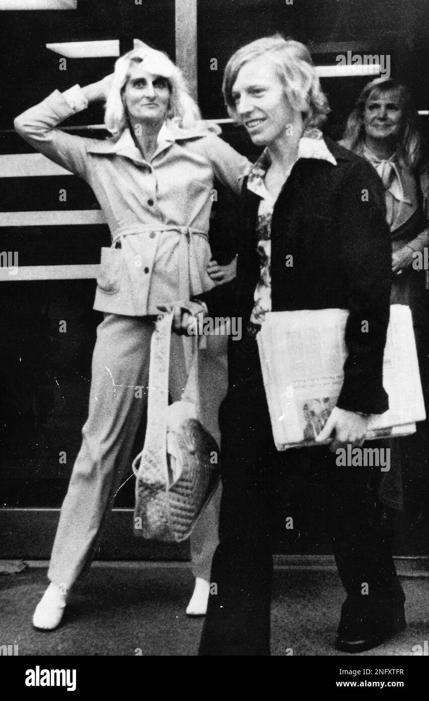 Betty Kallinger, wife of accused murderer Joseph Kallinger, strikes a pose for photographers as she leaves the Bergen County Courthouse after observing trial session, Oct. 6, 1976. Her husband is on trial for the murder of nurse Maria Fasching. At right is her son-in-law Leon Workman. (AP Photo) Banque D'Images