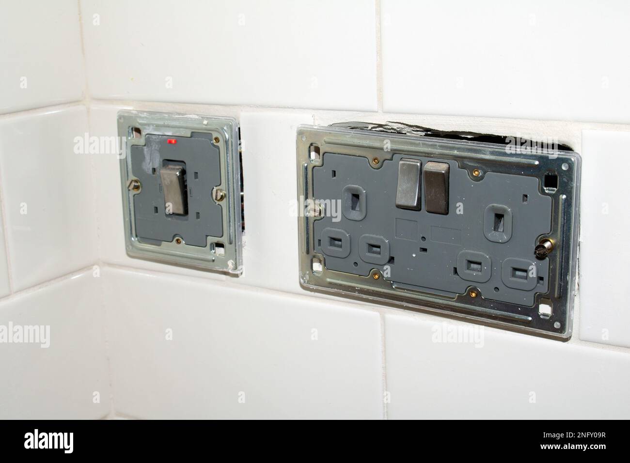 Un disjoncteur électrique dans un mur blanc. Gros plan.de bouchons de rénovation non finis Banque D'Images