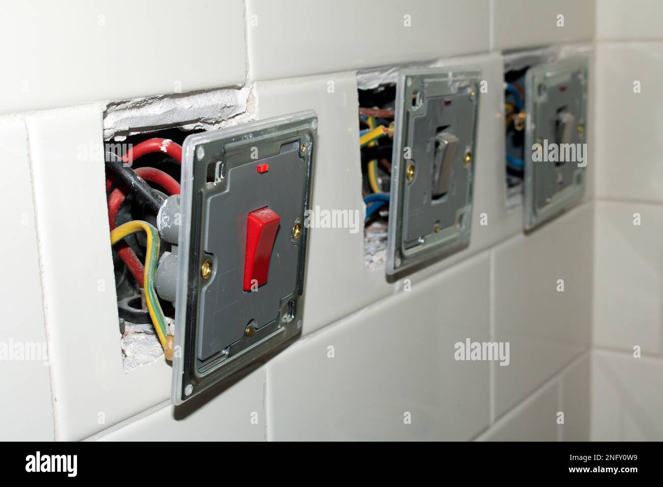 Un disjoncteur électrique dans un mur blanc. Gros plan.de bouchons de rénovation non finis Banque D'Images